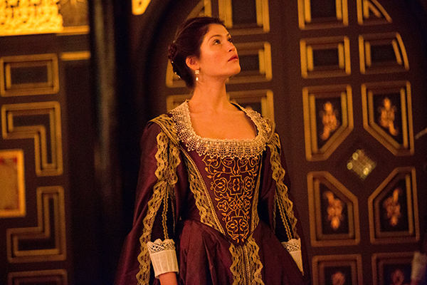 The Duchess of Malfi A woman standing in an old fashioned dress on the Sam Wanamaker Playhouse stage