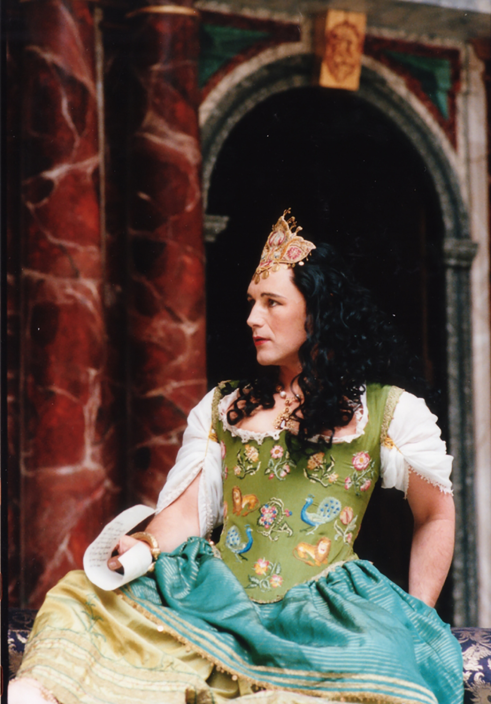 Mark Rylance Cleopatra Shakespeare's Globe A man wearing a green corset dress sits on the Globe Theatre stage.