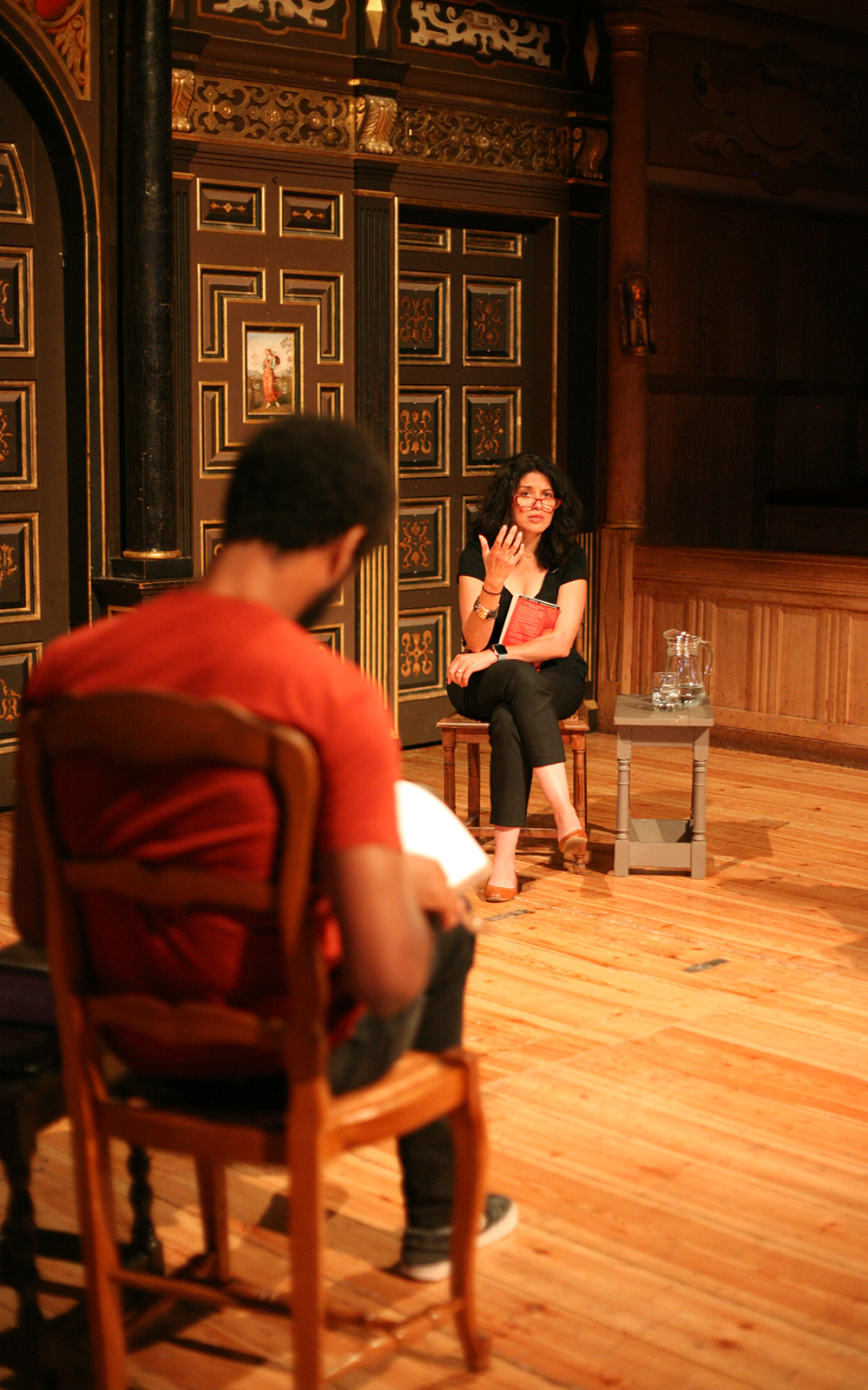 Globe Magazine Article Romeo and Juliet Shakespeare and Race A woman talks to a group onstage as they sit on chairs