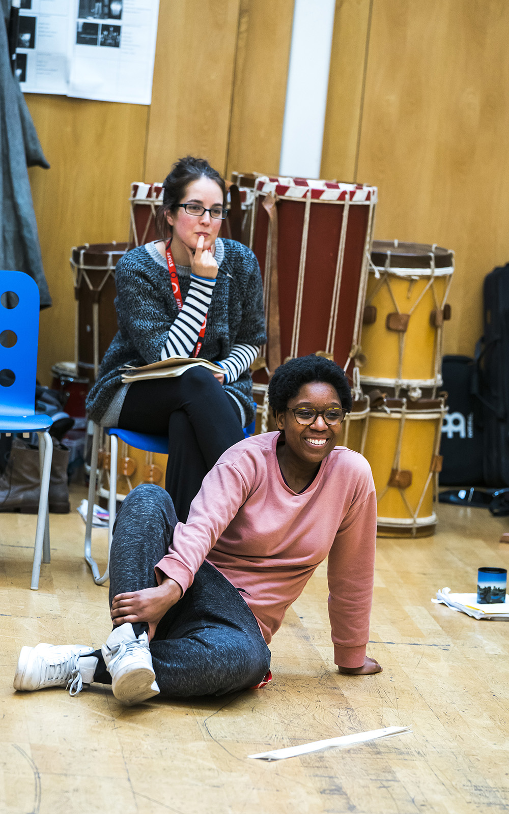 Leaphia Darko in Henry V rehearsals Two people are in a rehearsal, one is sat on a chair looking pensive, the other sits on the floor smiling