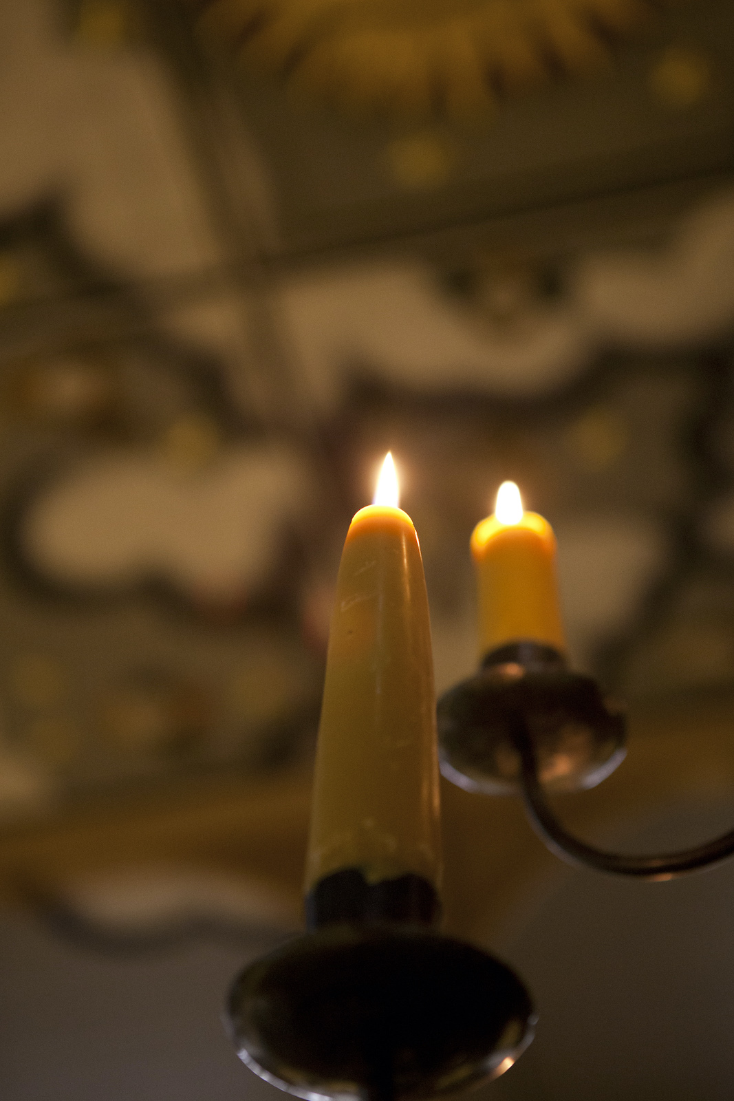 Two candles sit on a black candelabra