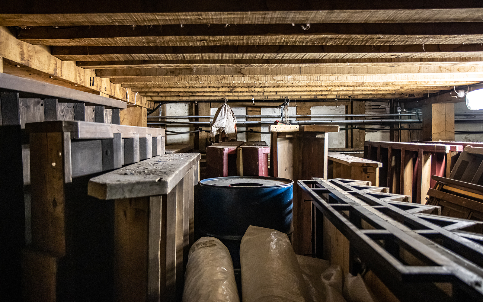 Heaven to Hell Globe Magazine Article Greg Morrison Under Stage Items of wooden staging and barrels are stored in a basement room