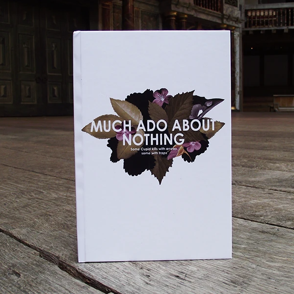 A white notebook with floral design and text reading: Much Ado About Nothing