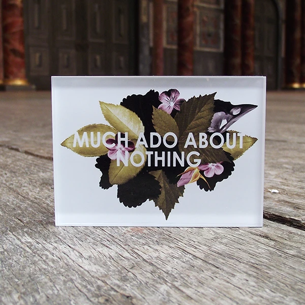 A white rectangular magnet with floral design and text reading: Much Ado About Nothing