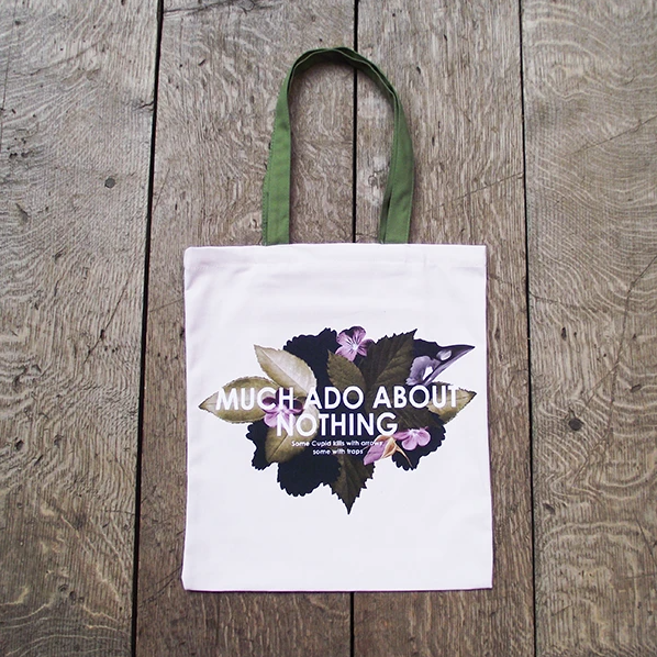 A white cloth tote bag with floral design and text reading: Much Ado About Nothing