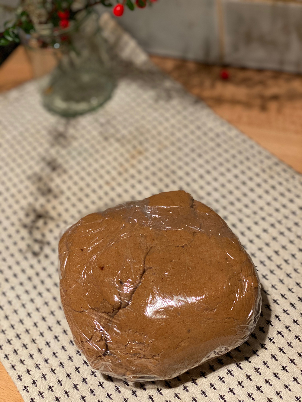 A ball of light brown biscuit mixture rests in cling-film.