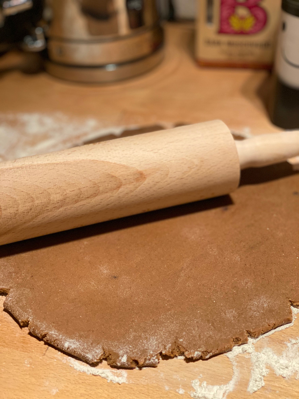 The biscuit dough is rolled out into a flat oval with a rolling pin.