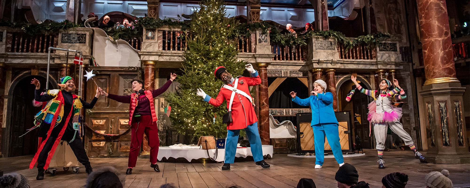 The cast of 'Christmas at the (Snow) Globe' dance in front of a Christmas tree