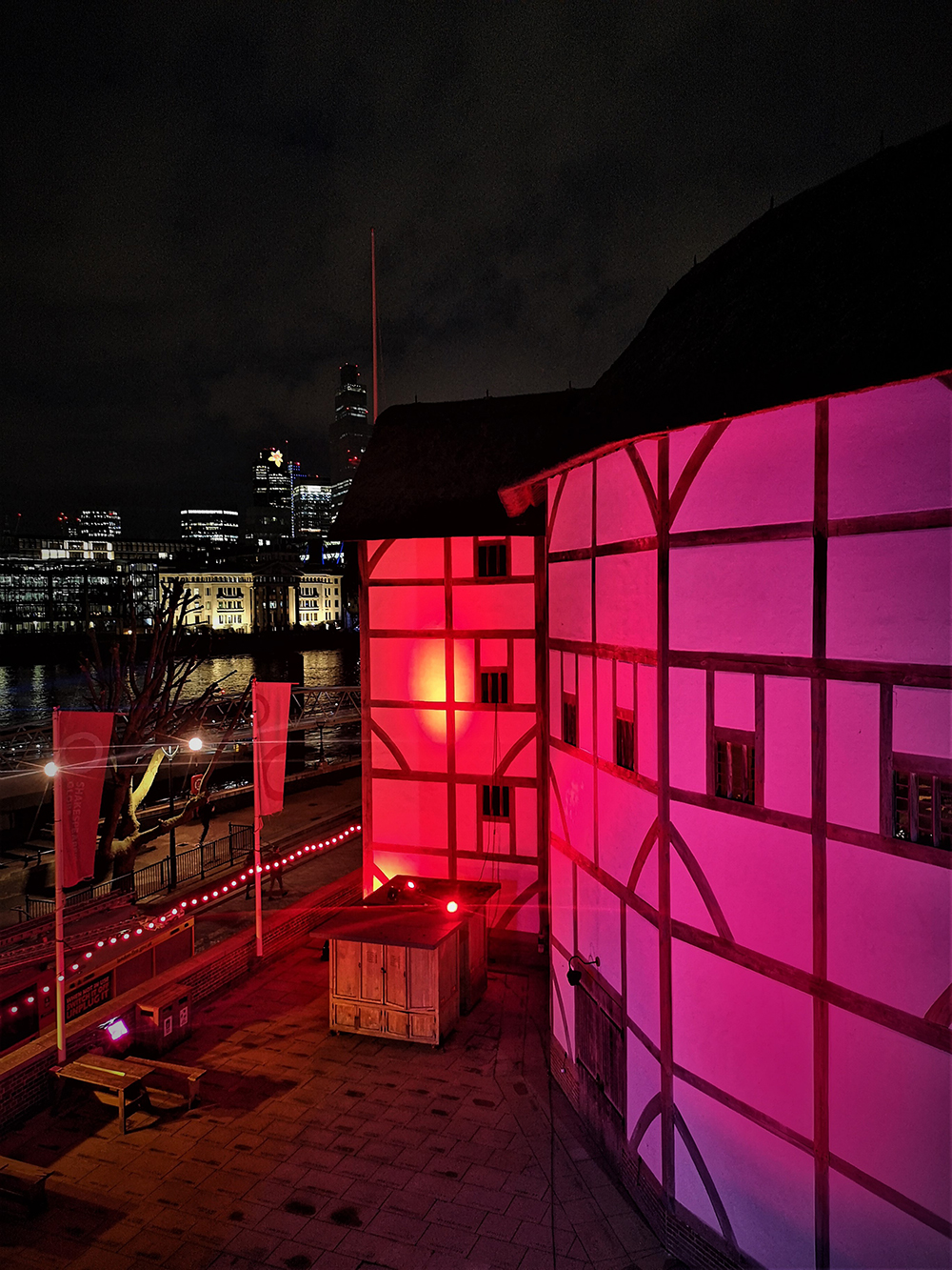 Light It In Red March 2021 Shakespeare's Globe 5 The normal white walls of the Globe Theatre are lit by red light.