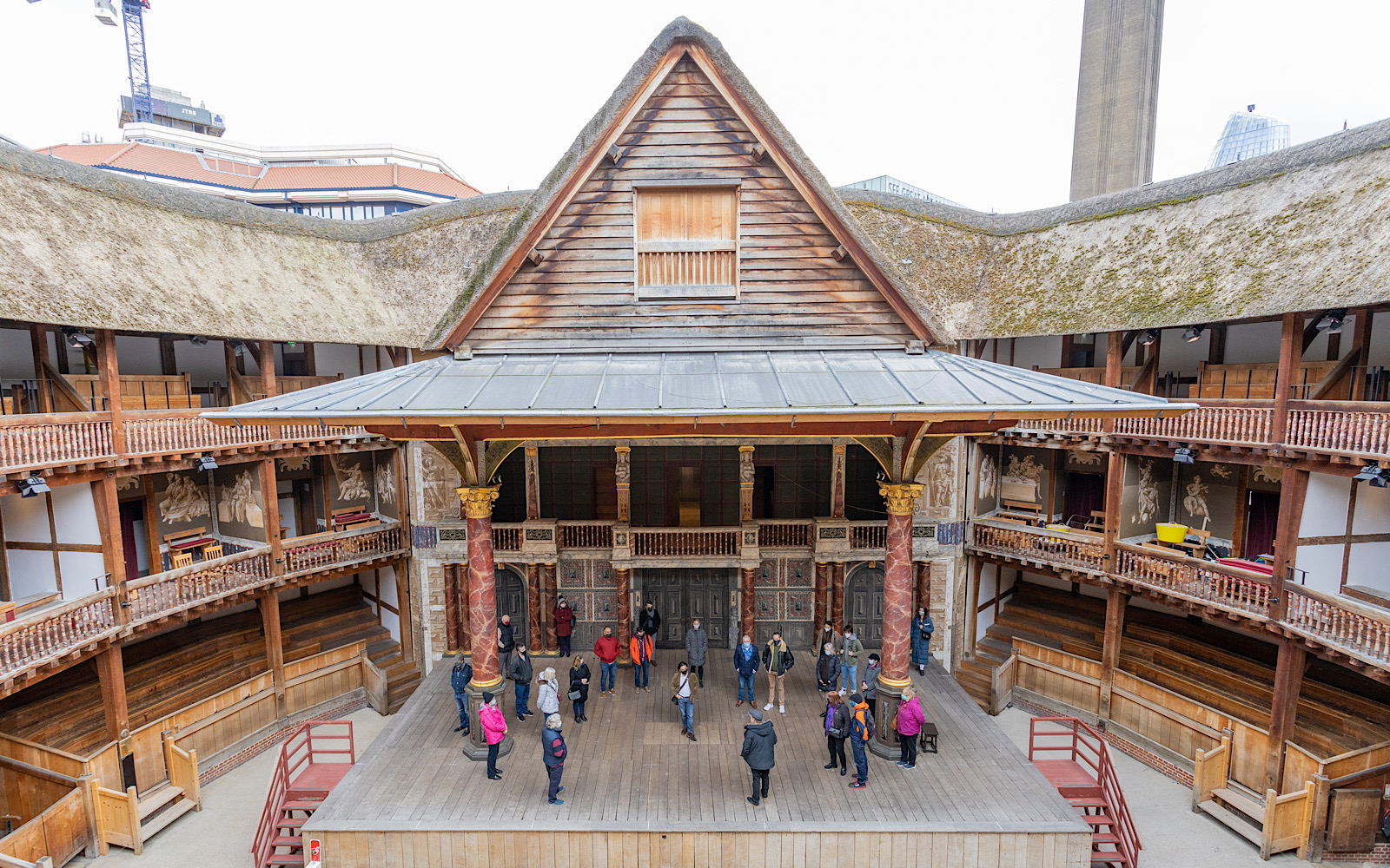 The Globe Theatre stage has a tall triangle roof and is held up by intricately decorated pillars