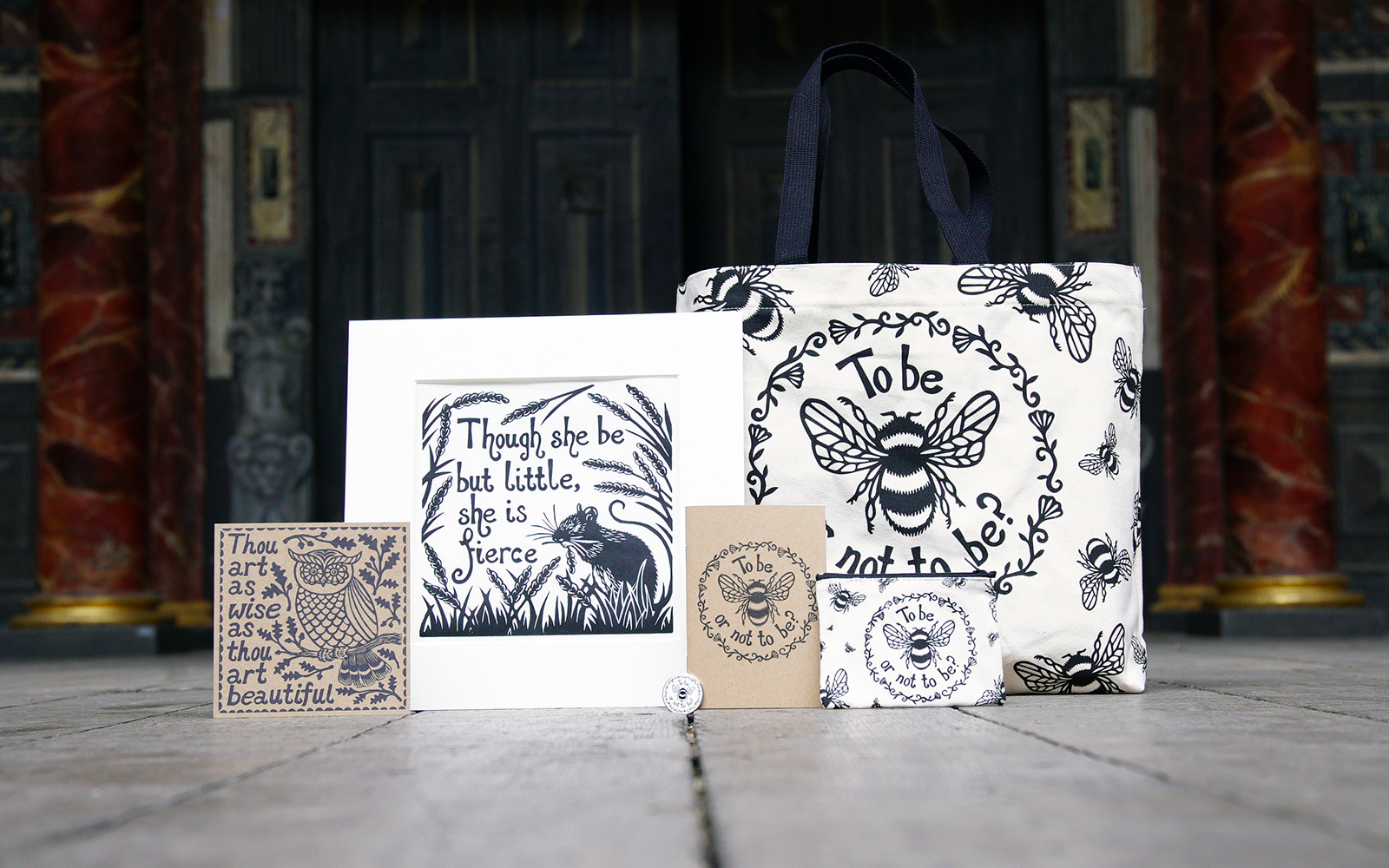A selection of white and beige products, including a print, card, tote bag, notebook and purse, featuring a illustrative screen printing design of bees, flowers, and animals.