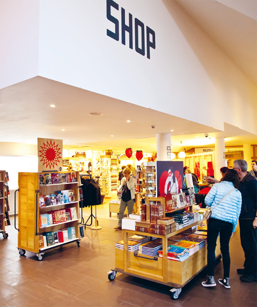 Shakespeare's Globe Gift Shop Customers browse a display of books in a shop.