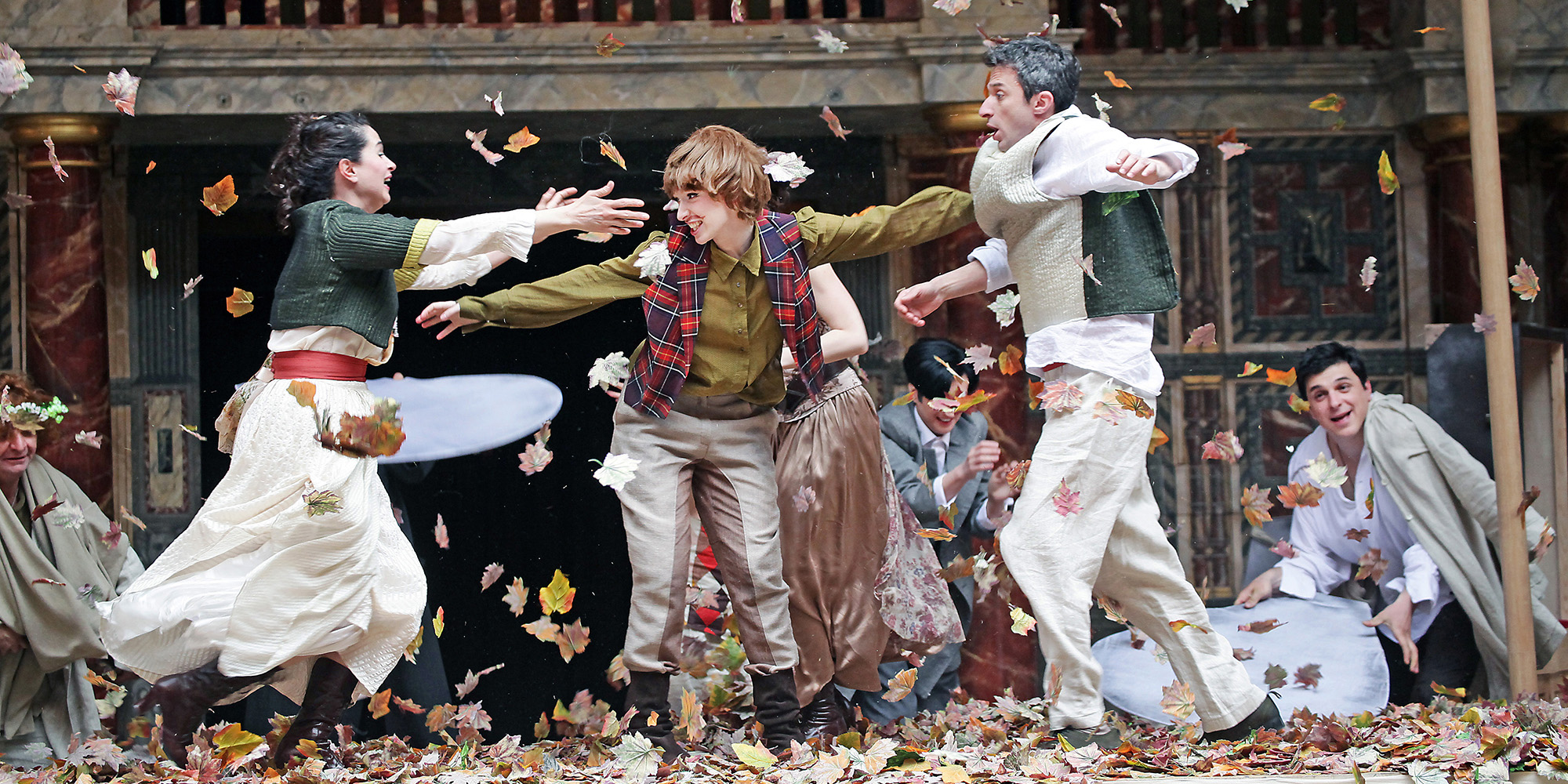 Actors on the stage that look as if they were playing in leaves