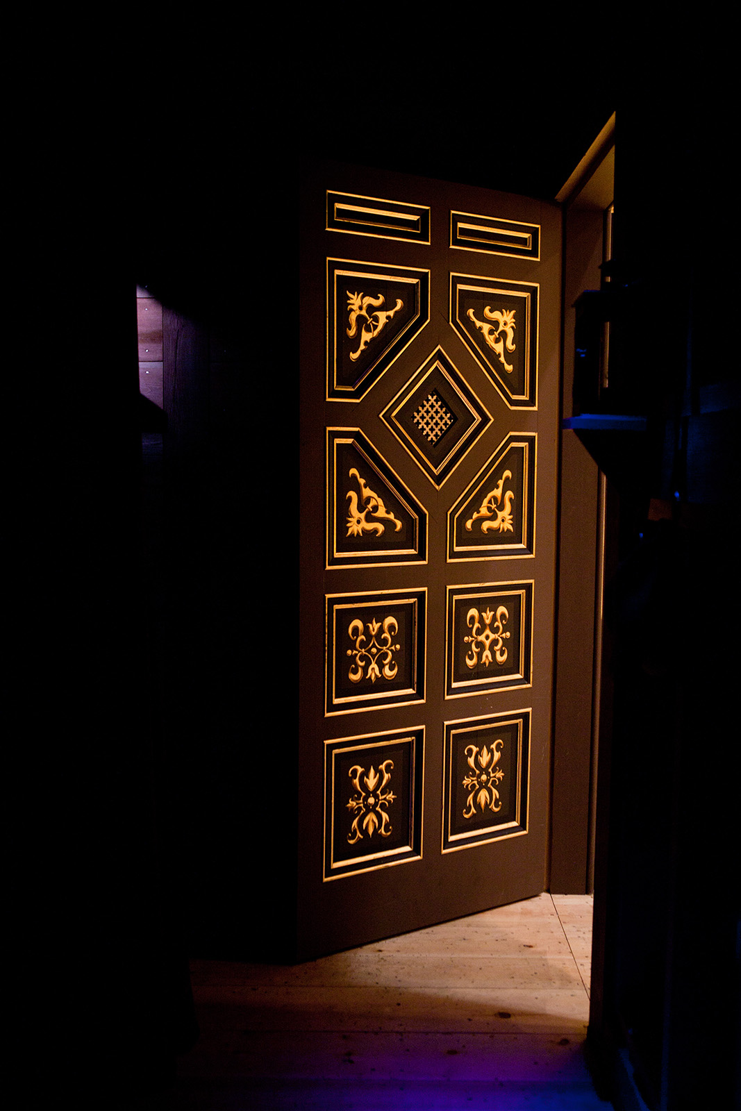 Tiring House Sam Wanamaker Playhouse 2021 A painted panelled door stands ajar, with sable and gold detailing.