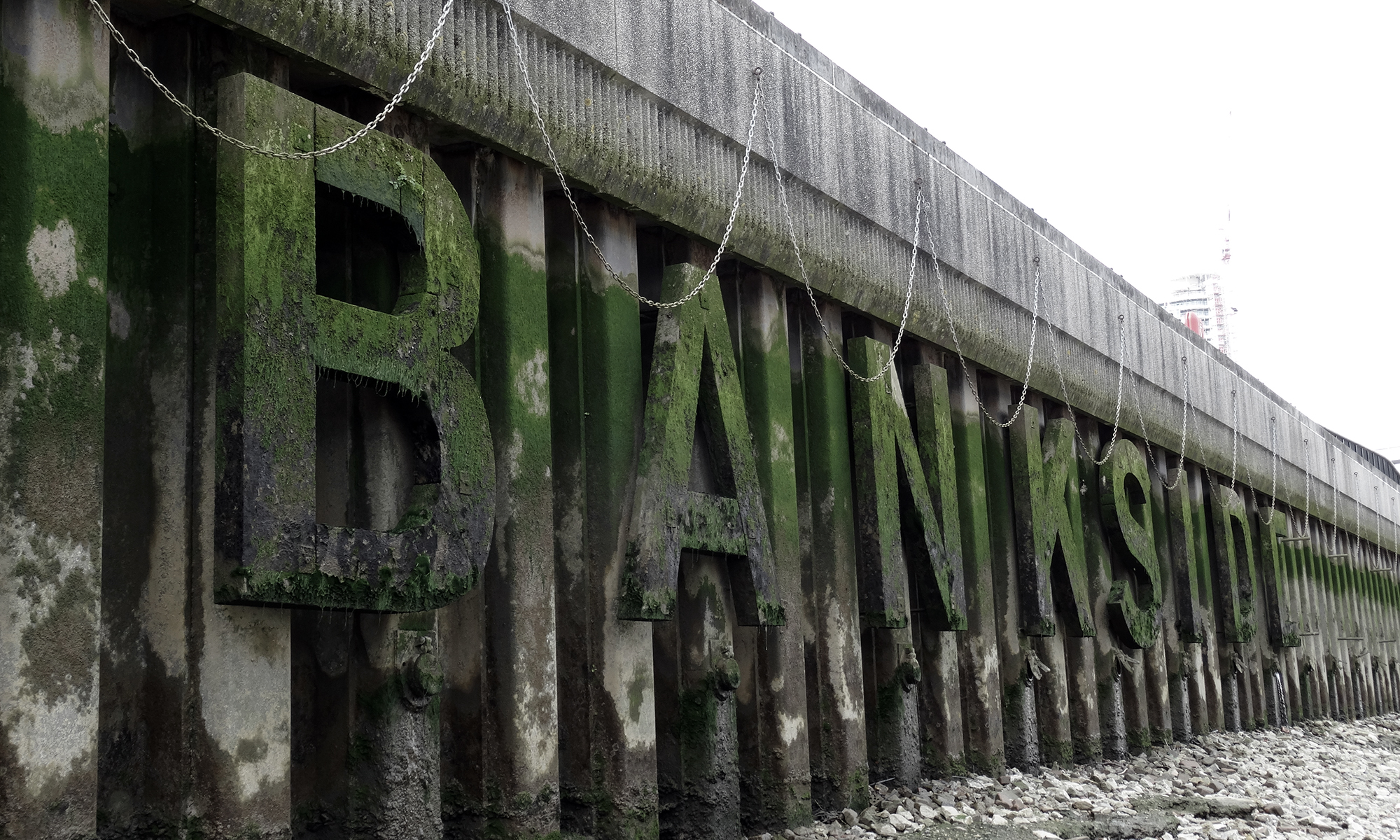Large algae-covered letters spell out 'BANKSIDE' fixed to the riverbank wall.
