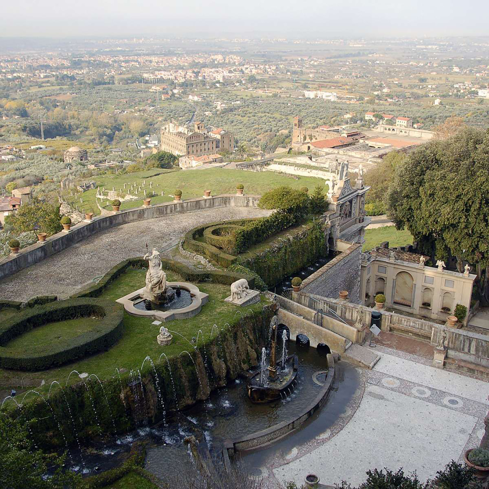 An aerial photograph of an Italian garden, with sculptured paths and lawns and a water fountain.
