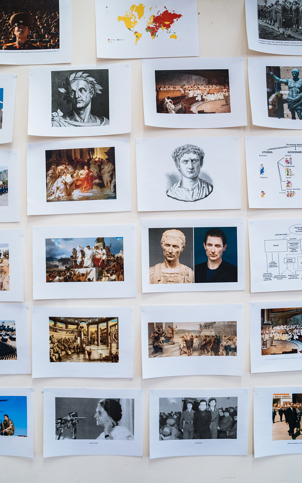 [image] A series of printed images are pinned to a rehearsal room wall depicting historical paintings and status of events and people from Ancient Rome.